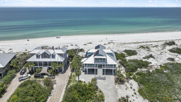 A beachfront property with multiple houses, a sandy beach, and the ocean. - Graceland: Stunning Views, Screened Porch, End of North Cape! (Cape San Blas)