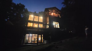 Un edificio de dos pisos con ventanas amplias y un balcón.