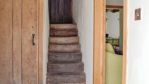 A wooden staircase leading to a room with a green sofa. - 3 bedroom accommodation in Llandybie, near Llandeilo (Llandybie, near Llandeilo)
