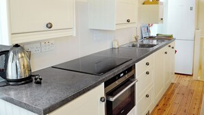 Eine moderne Küche mit Einbauofen, Geschirrspüler und einer Arbeitsplatte mit Wasserkocher.