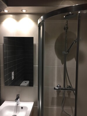 Een douche, een haardroger, handdoeken, toiletpapier