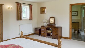 A bedroom with a bed, a dresser, a mirror, a radiator, and a window with curtains. - 1 bedroom accommodation in Cropton, near Pickering (Cropton, near Pickering)