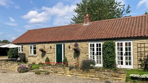 A stone building with a red-tiled roof, a green door, and white-framed windows. - 1 bedroom accommodation in Cropton, near Pickering (Cropton, near Pickering)