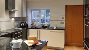 A modern kitchen with a black countertop, stainless steel appliances, and a window providing natural light.