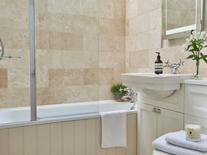 A bathroom with a bathtub, a sink, a mirror, a plant, and a candle. - 3 bedroom accommodation in Pickering (Pickering)