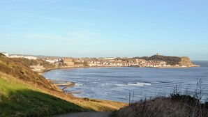 A coastal cityscape with a prominent hill, a river, and a fortified structure. - 3 bedroom accommodation in Pickering (Pickering)