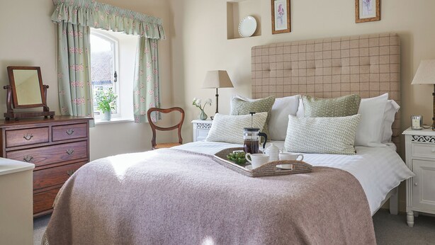 A bedroom with a bed, dresser, nightstand, lamp, and a window with curtains. - 3 bedroom accommodation in Pickering (Pickering)