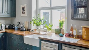 Una cocina equipada con lavavajillas, tostadora, hervidor y ventana con vistas al exterior.