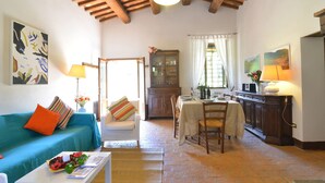Una sala de estar acogedora con un sofá, una mesa de comedor y una zona de cocina.