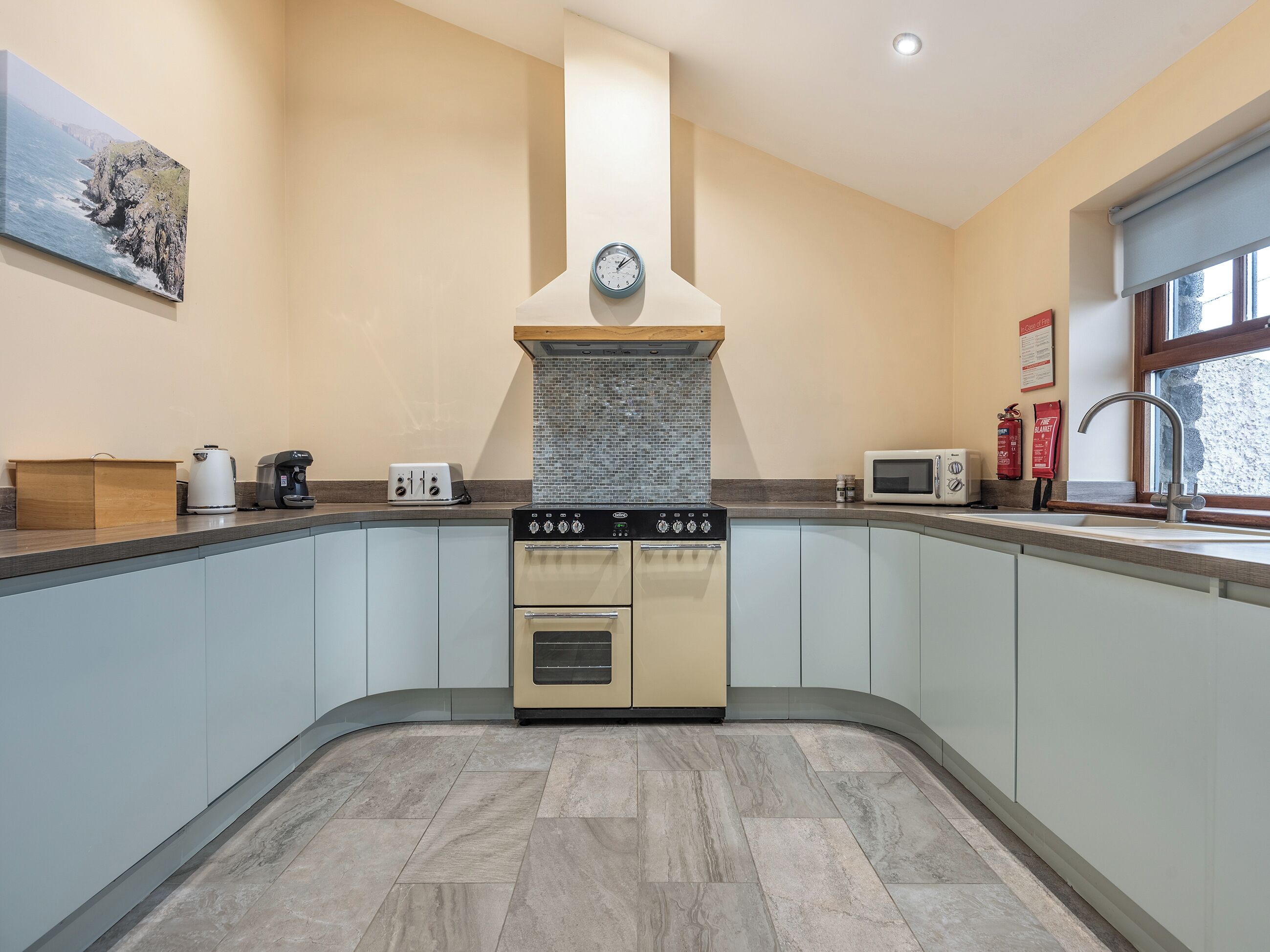 A kitchen with a built-in oven, a microwave, a coffee maker, and a toaster.