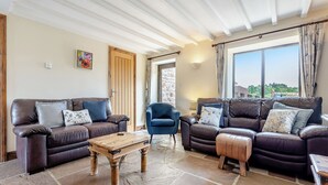 A spacious living room with leather sofas, a wooden coffee table, and a stone floor. - 4 bedroom accommodation in Beck Hole, near Goathland (Beck Hole, near Goathland)