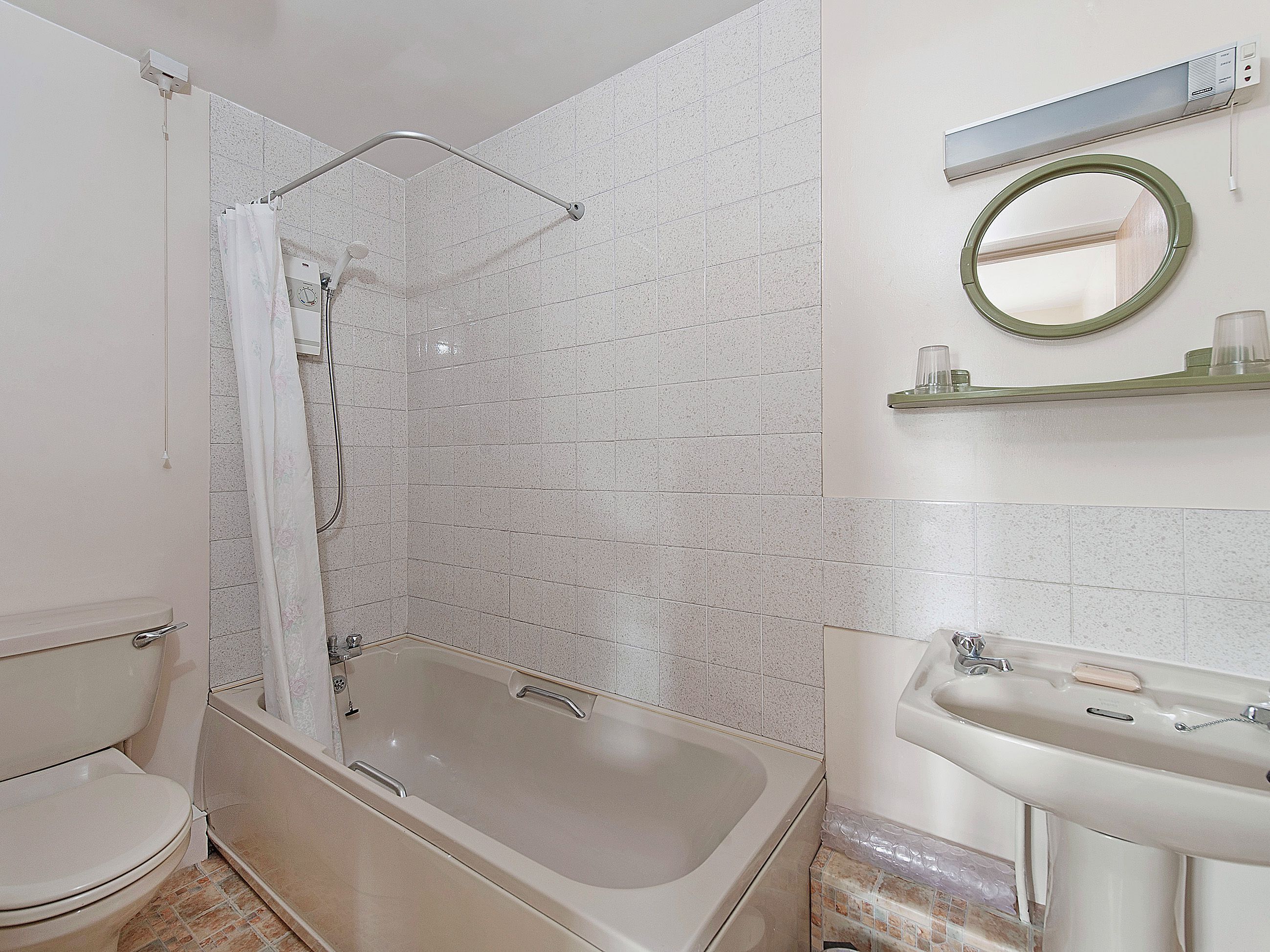 Une salle de bain avec une baignoire, une douche, un lavabo et un miroir.