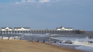 Um cais que se estende para o mar, com edifícios no final.