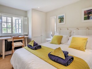 Un dormitorio con una cama, un escritorio y una silla.