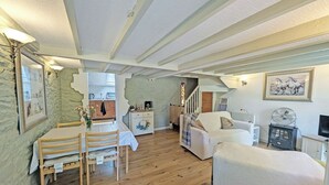 A cozy living room with a dining area, wooden flooring, and a staircase leading to an upper level. - 2 bedroom accommodation in Llannon, Llanelli (Llannon, Llanelli)