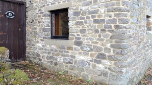 A stone building with a wooden door and a small window. - 1 bedroom accommodation in Castleton (Castleton)