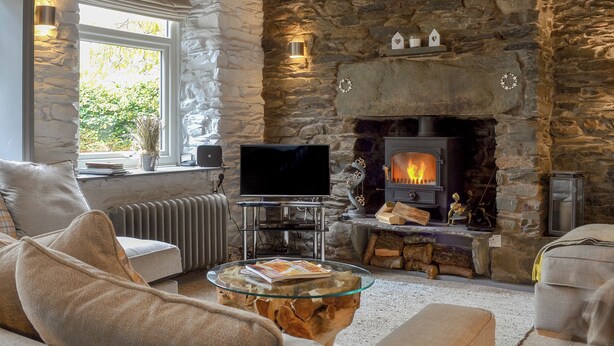 A cozy living room with a stone fireplace, a television, and comfortable seating. - Coach House Grasmere (Grasmere)