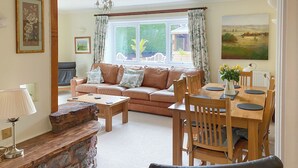 A cozy living room with a sofa, coffee table, and dining table set for four. - 3 bedroom accommodation in Fitzhead, near Wivelscombe (Fitzhead, near Wivelscombe)