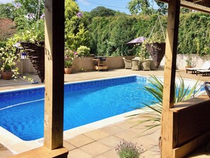 A rectangular swimming pool with a wooden deck surrounding it. - 3 bedroom accommodation in Fitzhead, near Wivelscombe (Fitzhead, near Wivelscombe)