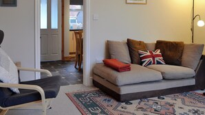A living room with a sofa, a chair, a rug, and a painting on the wall. - 2 bedroom accommodation in Buxton (Buxton)