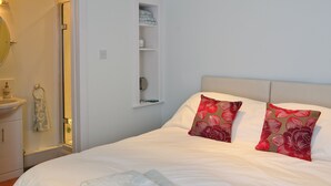 A neatly made bed with white linens, two decorative pillows, and two folded towels. - 1 bedroom accommodation in Moffat (Moffat)
