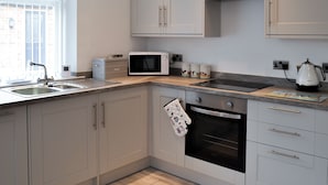 A kitchen with a microwave, oven, and sink.