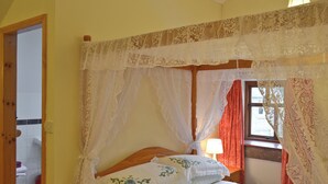 A bedroom with a four-poster bed, a bedside table with a lamp, and a window with curtains. - 1 bedroom accommodation in Cromford, near Matlock (Cromford, near Matlock)