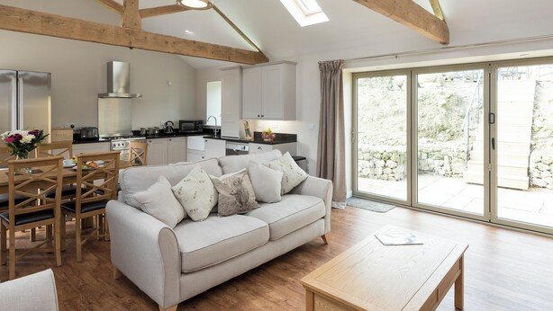 A spacious living area with a sofa, dining table, and kitchen in the background. - 3 bedroom accommodation in Ventnor (Ventnor)