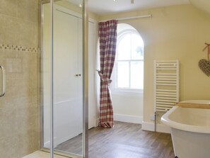 A bathroom with a glass shower door, a window with a checkered curtain, a white bathtub, and a heart-shaped decoration on the wall. - Islabank Farmhouse - SAAP (Meigle)