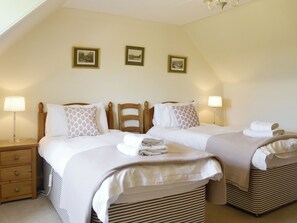 A hotel room with two beds, a nightstand, and a lamp. There are three framed pictures on the wall. - Islabank Farmhouse - SAAP (Meigle)
