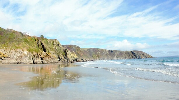 A beach with a rocky cliff and waves crashing onto the shore. - 3 bedroom accommodation in Gorran Haven (Gorran Haven)