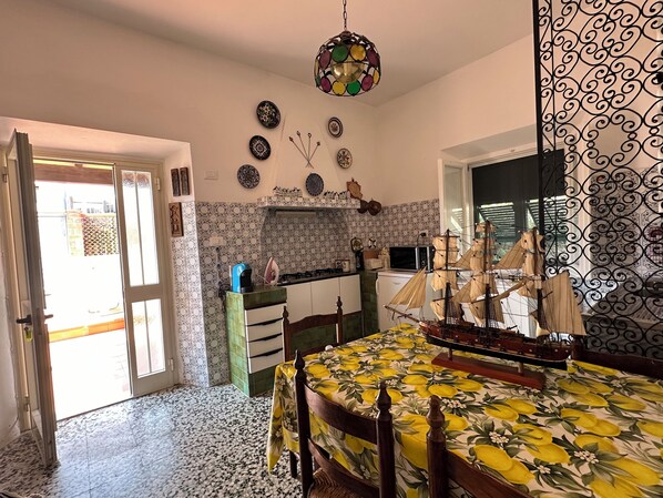 Una habitación con cama, una mesa, una kitchenette y un modelo decorativo de barco.