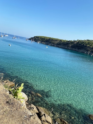 A coastal scene with clear water, boats, and rocky terrain. - Best panoramic apartment - Fetovaia, Elba <br> apartment with a view in Fetovaia (Fetovaia)