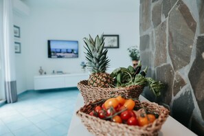Eine Küche mit einer Steinwand, einer weißen Arbeitsplatte und einem Fernseher an der Wand.