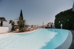A swimming pool with lounge chairs and palm trees. - VillaBiancaSorrento-Sea View-Private Pool-Heated Jacuzzi-Gym-Private Car Park (Sorrento)