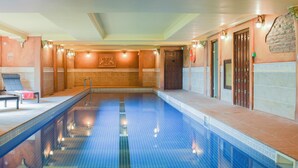 An indoor swimming pool with clear blue water, a tiled floor, and a bench on one side. - THE OLD SHEAF STORE - KYZ (Glaisdale, near Whitby)