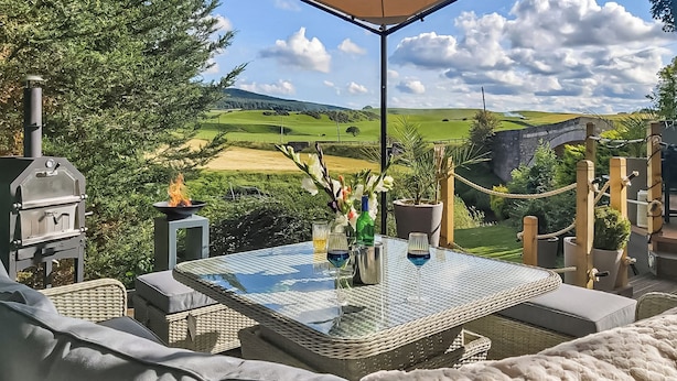 An outdoor patio with wicker furniture, a glass table, and a barbecue grill. - 2 bedroom accommodation in Lanark (Lanark)