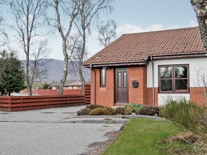 A brick house with a tiled roof, a front door, and a mailbox. - 2 bedroom accommodation in Dalfaber, Aviemore (Dalfaber, Aviemore)