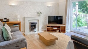 A living room with a fireplace, a television, a sofa, and a coffee table. - Looking for a romantic escape in Herefordshire’s rolling countryside. (Tarrington, near Ledbury)
