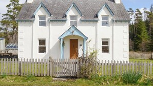Un bâtiment blanc avec un toit bleu et une porte en bois.