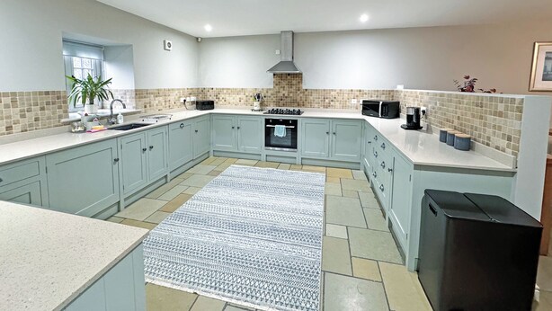 A modern kitchen with light blue cabinets, a central island, a built-in oven, a microwave, and a black refrigerator. - 3 bedroom accommodation in Tantobie, Stanley (Tantobie, Stanley)