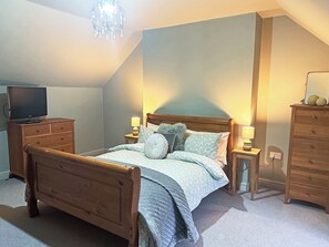 A bedroom with a wooden bed, a television on a dresser, and two bedside lamps. - 3 bedroom accommodation in Tantobie, Stanley (Tantobie, Stanley)