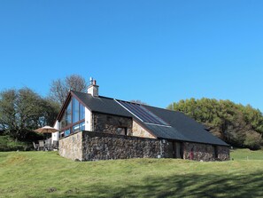 A stone building with a sloped roof, large windows, and a chimney. - 2 bedroom accommodation in Inverlussa, near Achnamara (Inverlussa, near Achnamara)