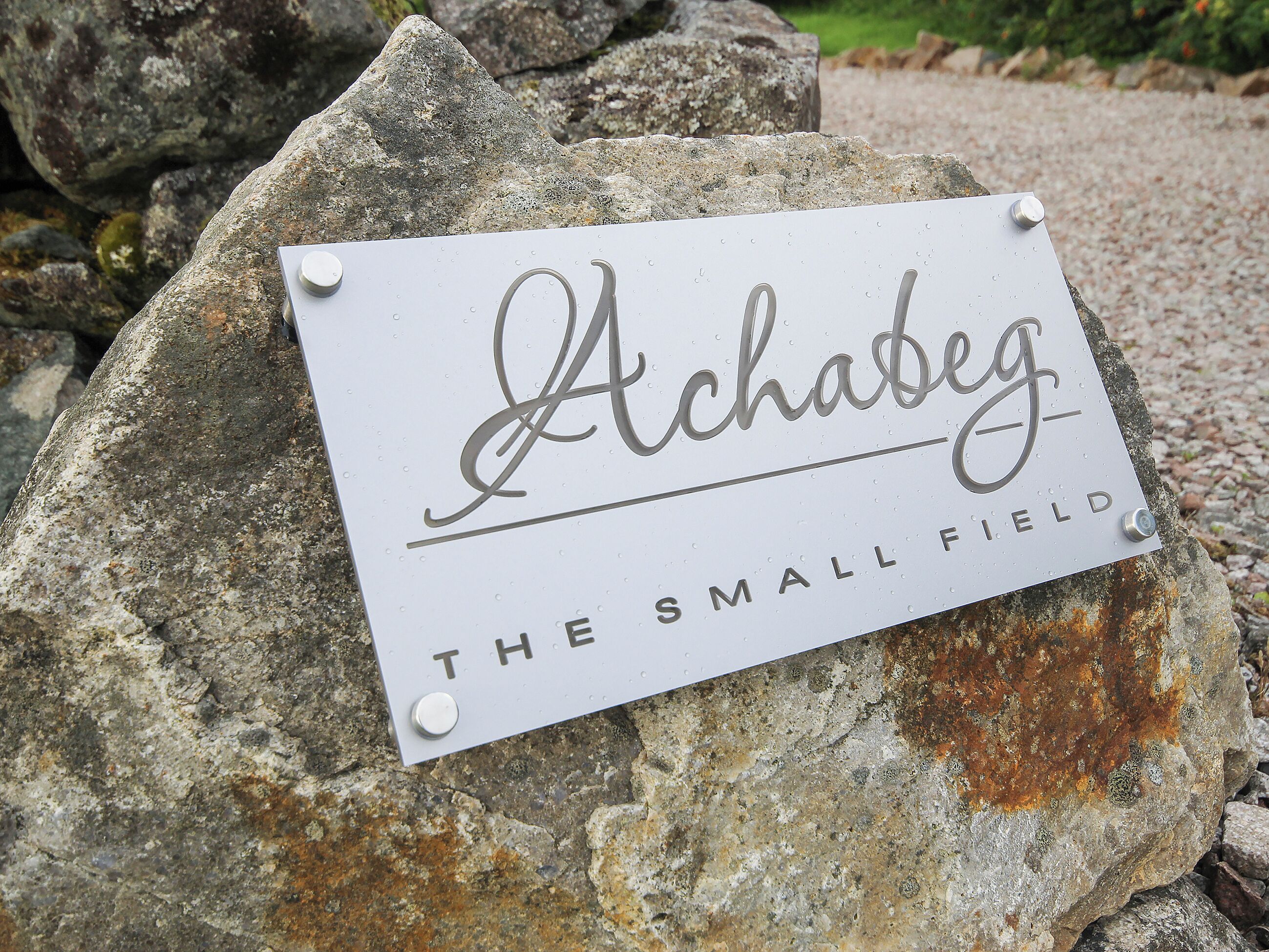 Une inscription sur un rocher portant le nom « Achabeg » et l’expression « Le Petit Champ ».