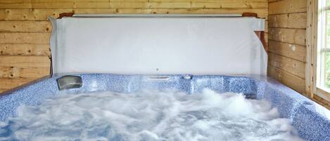 Una cabaña de madera con un jacuzzi.