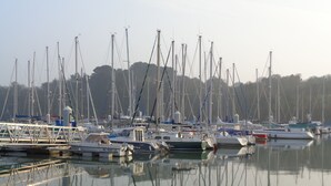 A marina with multiple boats docked, calm water, and a forested hill in the background. - PENVENAN 22710. House 4 PERSONS. Close to shops. 3km from beaches (Penvénan)