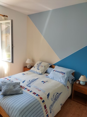 A bedroom with a bed, pillows, and a nightstand.