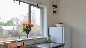 A kitchen with a window, sink, and a bowl of fruit on the counter. - 2 bedroom accommodation in Ardentinny, near Dunoon (Ardentinny, near Dunoon)