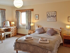 A bedroom with a bed, bedside tables, a dresser, a desk, and a window with curtains. - 2 bedroom accommodation in Near Marazion (Near Marazion)