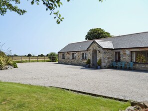 A stone building with a gravel driveway, a fenced field, and a clear sky. - 2 bedroom accommodation in Near Marazion (Near Marazion)